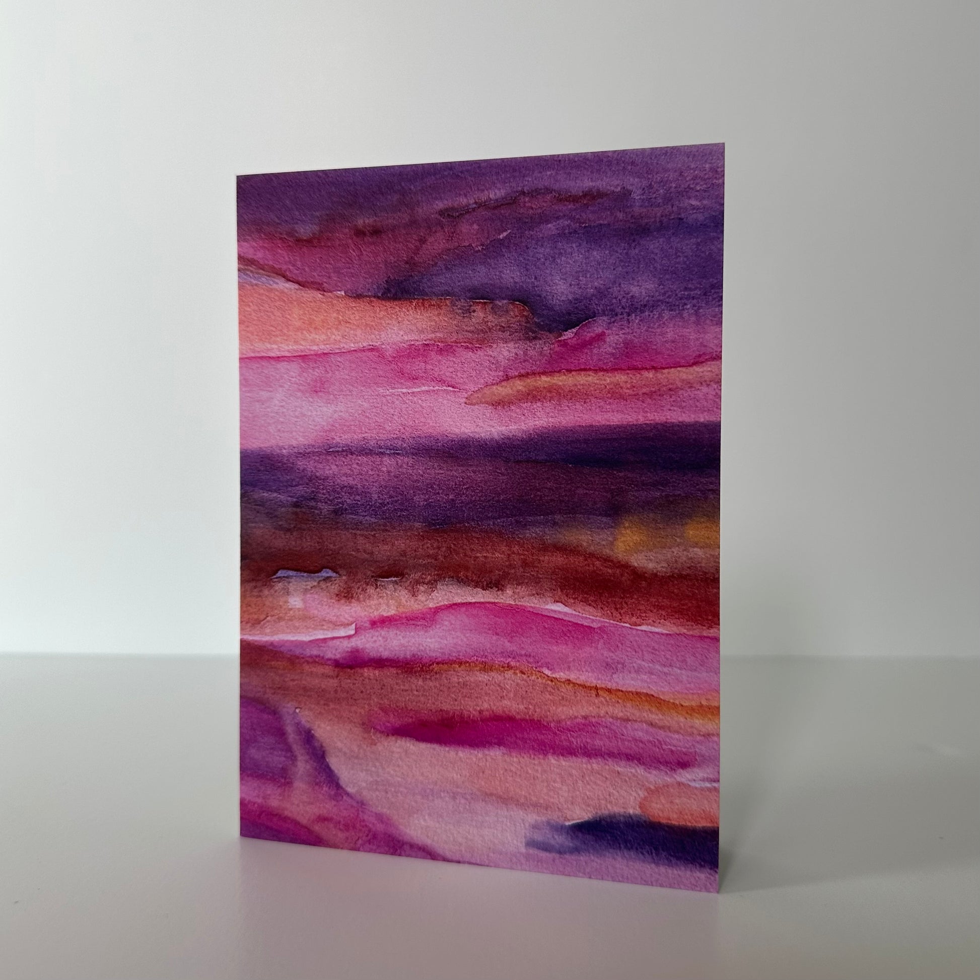 Abstract watercolor painting with purple and pink hues on a white background
