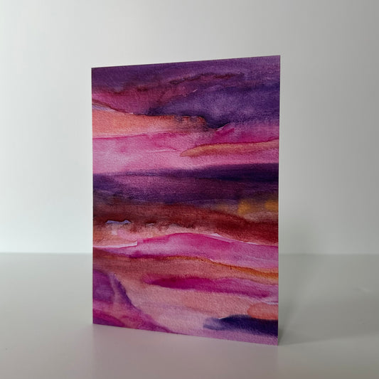 Abstract watercolor painting with purple and pink hues on a white background